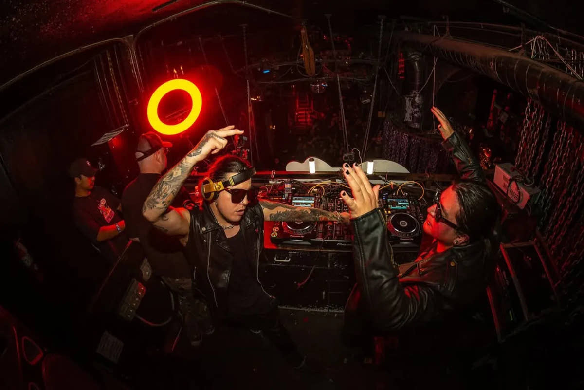 DJs performing inside Bar Sinister under red lighting