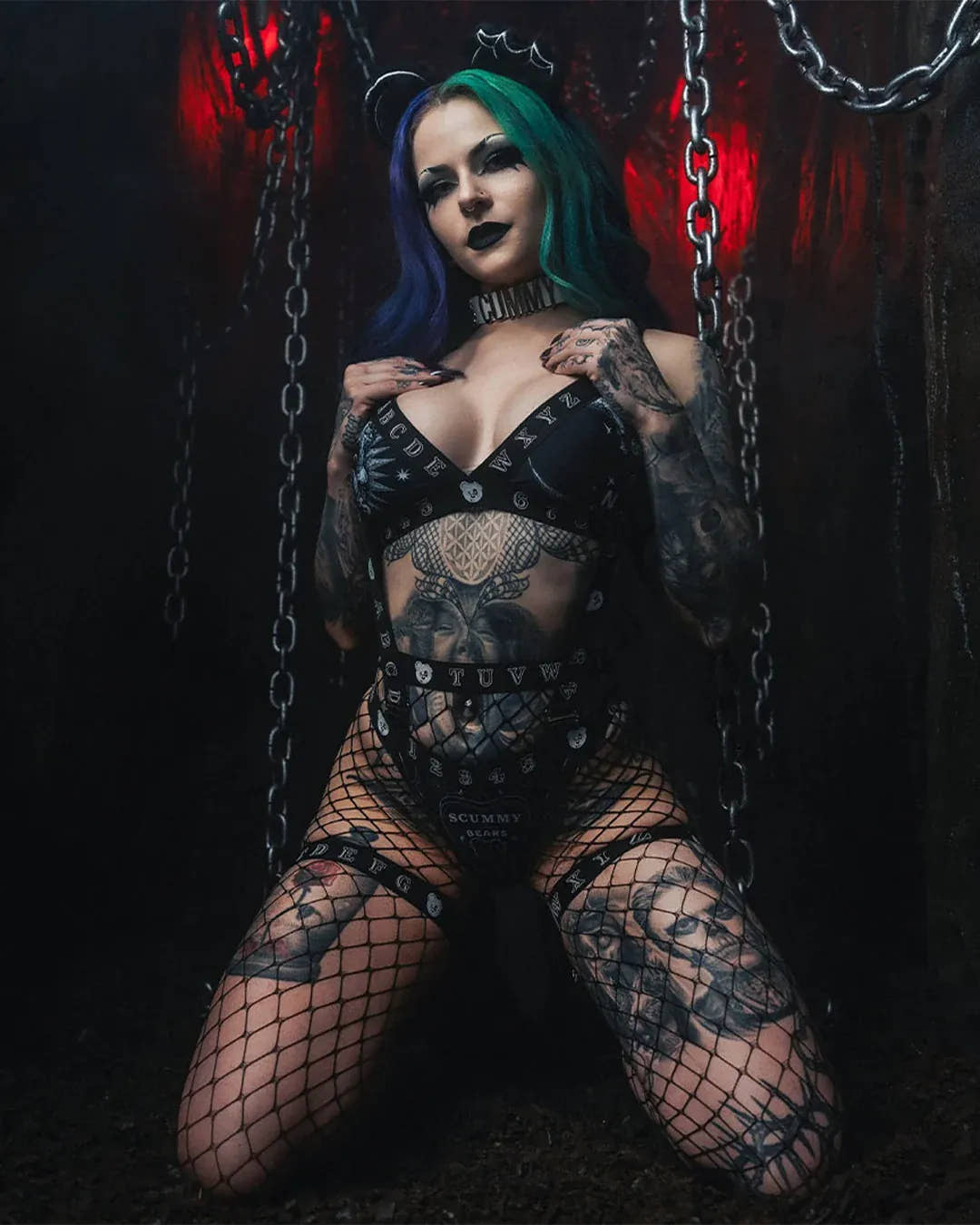 Model wearing the Scummy Bears Séance bikini set in a dark room filled with hanging chains
